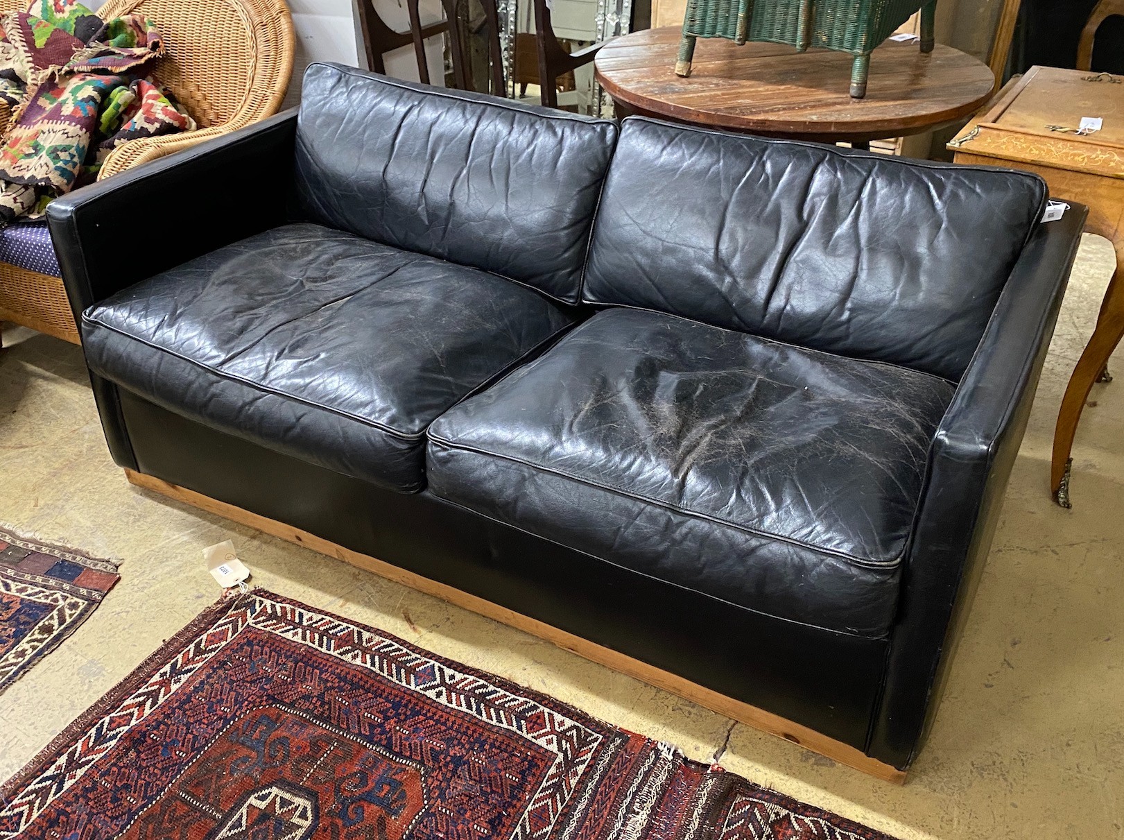 A black leather upholstered two seater sofa bed, length 172cm